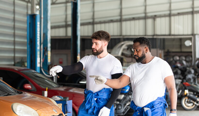 Car mechanic working in an auto repair shop, inspecting the operation of the car's air conditioner...