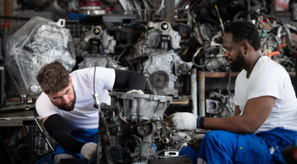 Two men repairing car engine in auto repair shop, Selective focus.