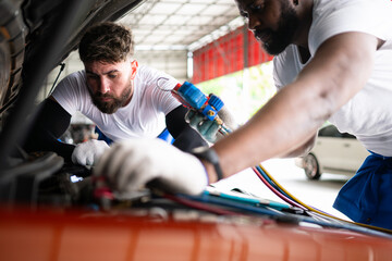 Car mechanic working in an auto repair shop, inspecting the operation of the car's air conditioner...