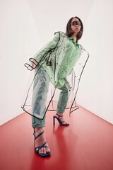 Futuristic fashion portrait of young Asian woman wearing plastic and posing on white