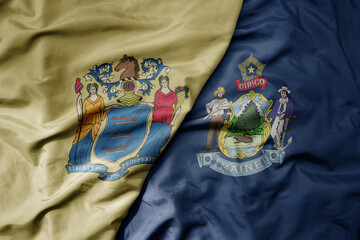 big waving colorful national flag of maine state and flag of new jersey state .