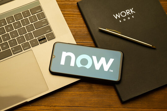 Kyoto city, Japan - July 31, 2023: Logo Servicenow on a smartphone near modern laptop on yellow wooden background
