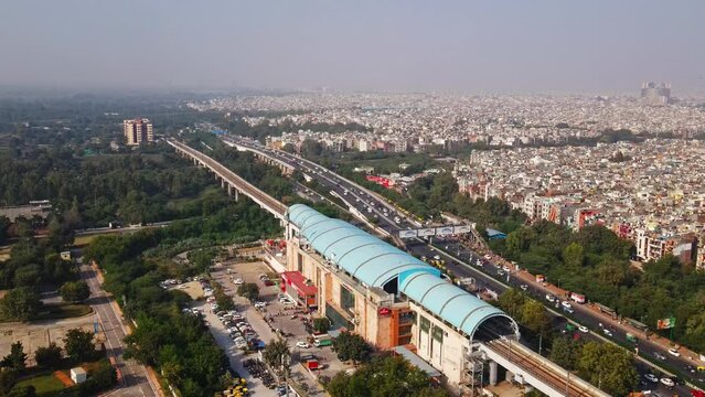 Aerial view of Indian capital and metropolitan city roads of New Delhi, India. Drone shot of 8-lane highway in Delhi. Roads of developing India. Metro rail track with highways and cityscape, India.