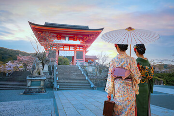 Young Japanese women in a traditional Kimono dress stroll in Kiyomizu-dera Buddhist temple in...