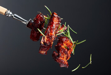 Grilled pork belly with rosemary on a fork. - obrazy, fototapety, plakaty