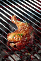 Chicken with rosemary on a grill.