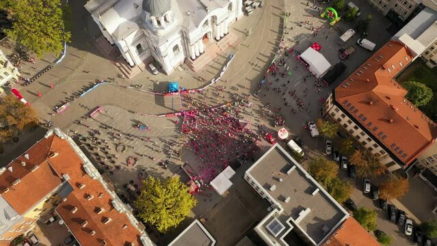 Drone footage of pre - marathon run warm up in a city center