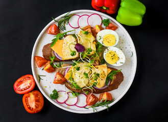toast with chicken breast, onion and vegetables on a white plate close up