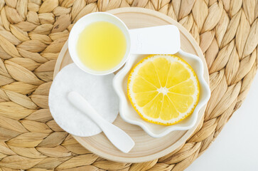 Lemon fruit slice and lemon juice for preparing homemade face toner or beauty mask. Natural beauty treatment and spa recipe. Top view.