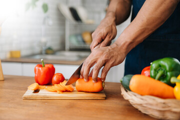 Man hands preparing a healthy salad. Cutting vegetables tomatoes on a cutting board