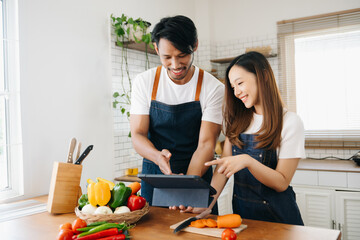 A man in the kitchen preparing a meal with Bread and fruit in cozy kitchen while his wife hugging him..