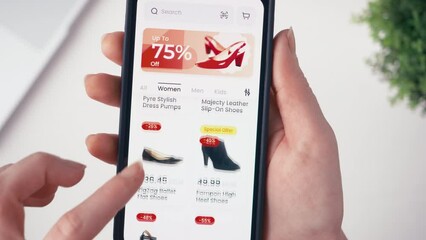 Christmas online shopping using smartphone retail app. Holiday sale with great discounts and special offers. Scrolling through a catalog of shoes. Fictional interface.