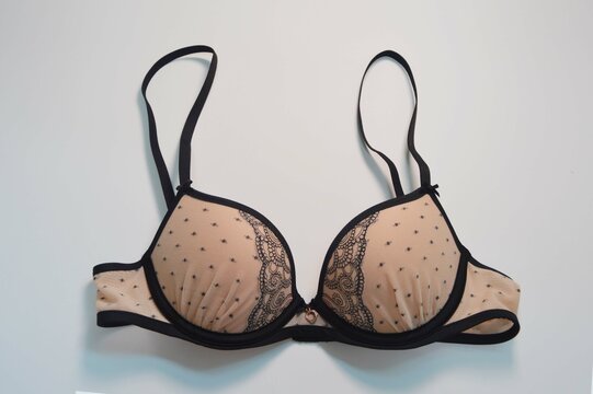 Lingerie. Beige bra with black lace on a white background. Fashionable beautiful women's underwear.