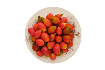 Tomatoes in a clay beige plate isolate on white background. Red farm tomatoes in rustic bowl. Top view.