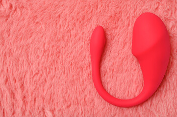 Pink dildo on a pink fur background. Top view.