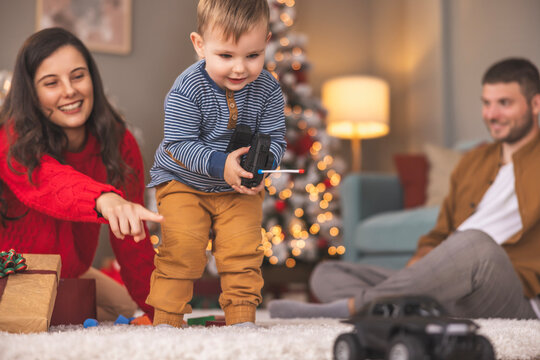 Toddler learning to play with remote controlled car toy he got as Christmas present