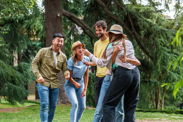 Joyful moment as friends share laughs and beers in a green park, conveying a relaxed and happy gathering.