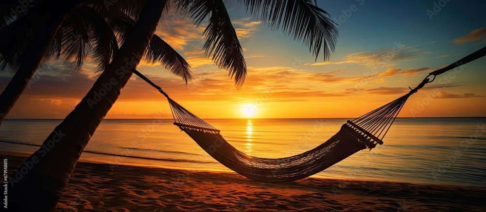 Wall mural Hammock on palm trees at sunset representing carefree freedom on a tropical beach Summer nature exotic shore Tranquil travel paradise Enjoy life positive energy Copy space image Place for addin - Wall murals