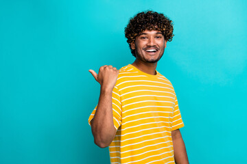 Photo portrait of attractive young man point empty space dressed stylish striped yellow clothes isolated on cyan color background