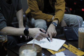 Two individuals engaged in a discussion, surrounded by paper with scribbles, capturing the essence of collaborative brainstorming