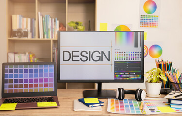 Graphic designer's workspace with a computer laptop and creative tools on the table