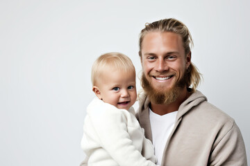 Smiling positive man holding his baby son, man expressing happiness, spending time with child, posing indoor at home