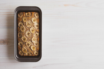 Delicious freshly baked homemade banana bread cake with no gluten and sugar free, top view on white wooden background, flat lay style. Healthy sweet food. Negative space for text.