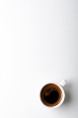 Cup of black coffee on white background. Black espresso coffee in white ceramic cup on white table, top view, copy space. 