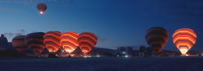 A panorama of the platform for preparing hot air balloons for takeoff, early in the morning, with...