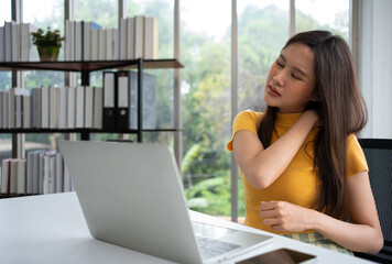 Beautiful young Asian businesswoman, shoulders and back pain during work long time on workplace....