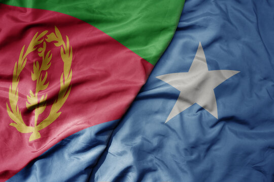 big waving national colorful flag of eritrea and national flag of somalia