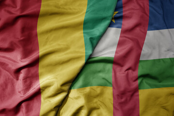 big waving national colorful flag of guinea and national flag of central african republic .