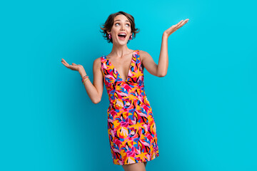 Photo of ecstatic woman with bob hair dressed colorful clothes look at empty space arms hold...