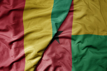 Obraz premium big waving national colorful flag of guinea and national flag of guinea bissau .