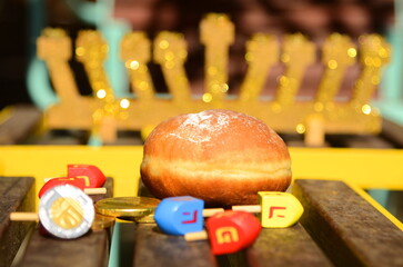 Hanukkah with wooden dreidels, menora,  sufganiyot, Chanukiahm coins shekel. Attributes of the Jewish holiday. 