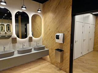 modern public toilet interior. empty public bathroom with sinks and wide wall mirrors. perspective