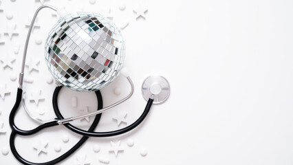 Christmas medical banner.Close-up of stethoscope,disco ball,stars and pills on white background,top...