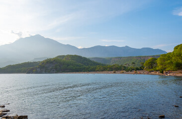 Captured the timeless beauty of the ancient city of Phaselis in Antalya's Kemer, nestled by the sea on a glorious sunny day. A mesmerizing panorama unfolds with the silhouette of mountains behind the 