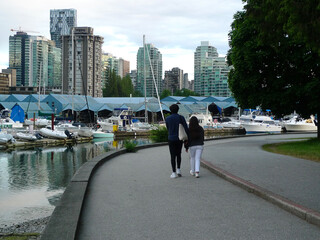 Yachts de luxe et bateaux à moteur amarrés au quai. Un couple se promène à la marina de Vancouver, Colombie-Britannique, Canada,  - 679189413