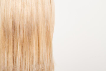 Fototapeta premium Natural looking shiny hair, fair blonde curls isolated on white background with copy space