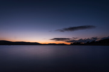 Fototapeta na wymiar long exposure of the sunset on the lake shore