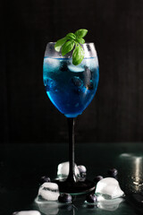 A glass of Blue Lagoon cocktail. on a dark background. a drink