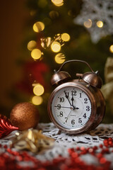 Photo of a clock on the background of a Christmas tree.