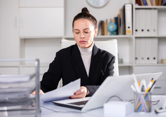 Successful business woman using laptop at workplace