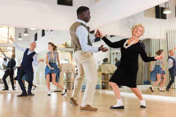 Photo sur Plexiglas École de danse Woman pensioner with african man practising charleston