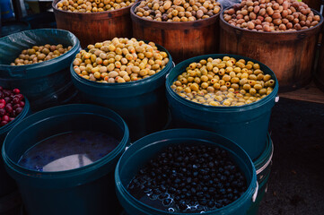 Different olives sale in the traditional farm Turkish market, a counter filled with fresh fruits
