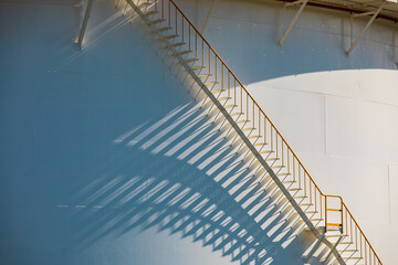 Detail of white tanks oil in tank farm with iron shadow