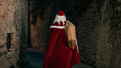 Obraz premium Santa Working outside with a bag full of presents
