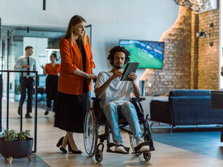 African-American businessman in a wheelchair engages in a collaborative discussion, using a tablet, with his business colleague, exemplifying the seamless integration of adaptive technology and - obrazy, fototapety, plakaty