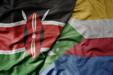 big waving national colorful flag of kenya and national flag of comoros .